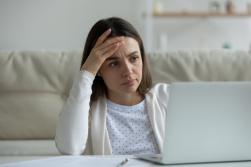 Mulher lendo notícia no computador com dúvida